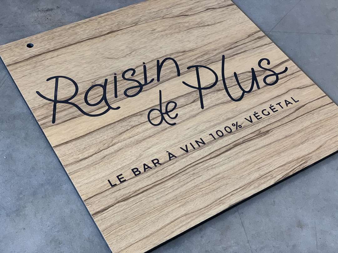 Découpe a la scie et gravure laser d'une enseigne drapeau pour le bar a vins Raisin de Plus à Bordeaux