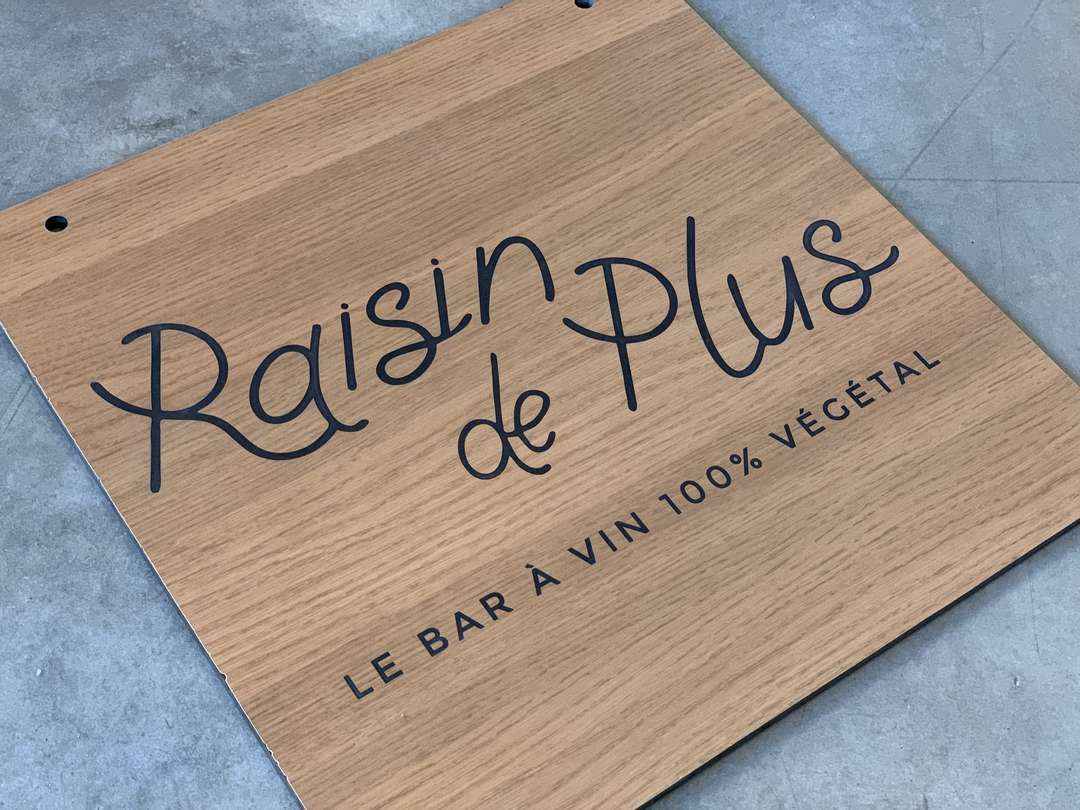 Découpe a la scie et gravure laser d'une enseigne drapeau pour le bar a vins Raisin de Plus à Bordeaux