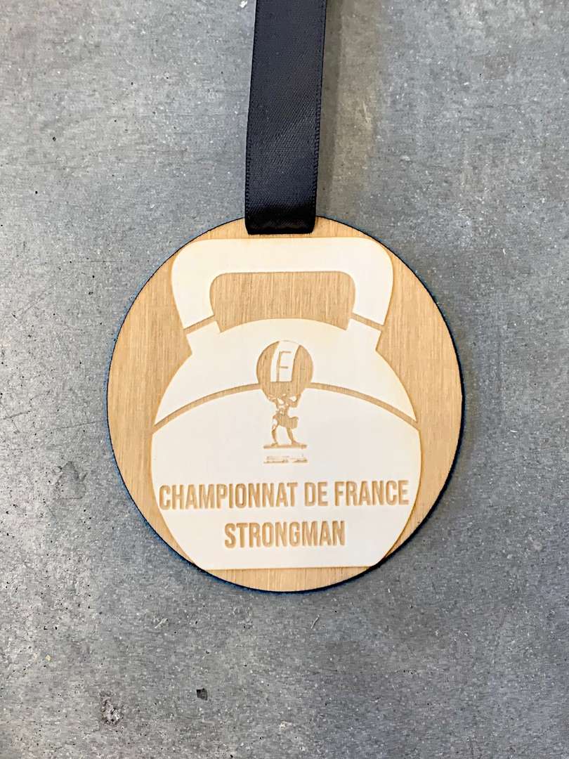 Gravure et découpe laser de médailles en bois pour le championnat de france strongman organisé par la break out company