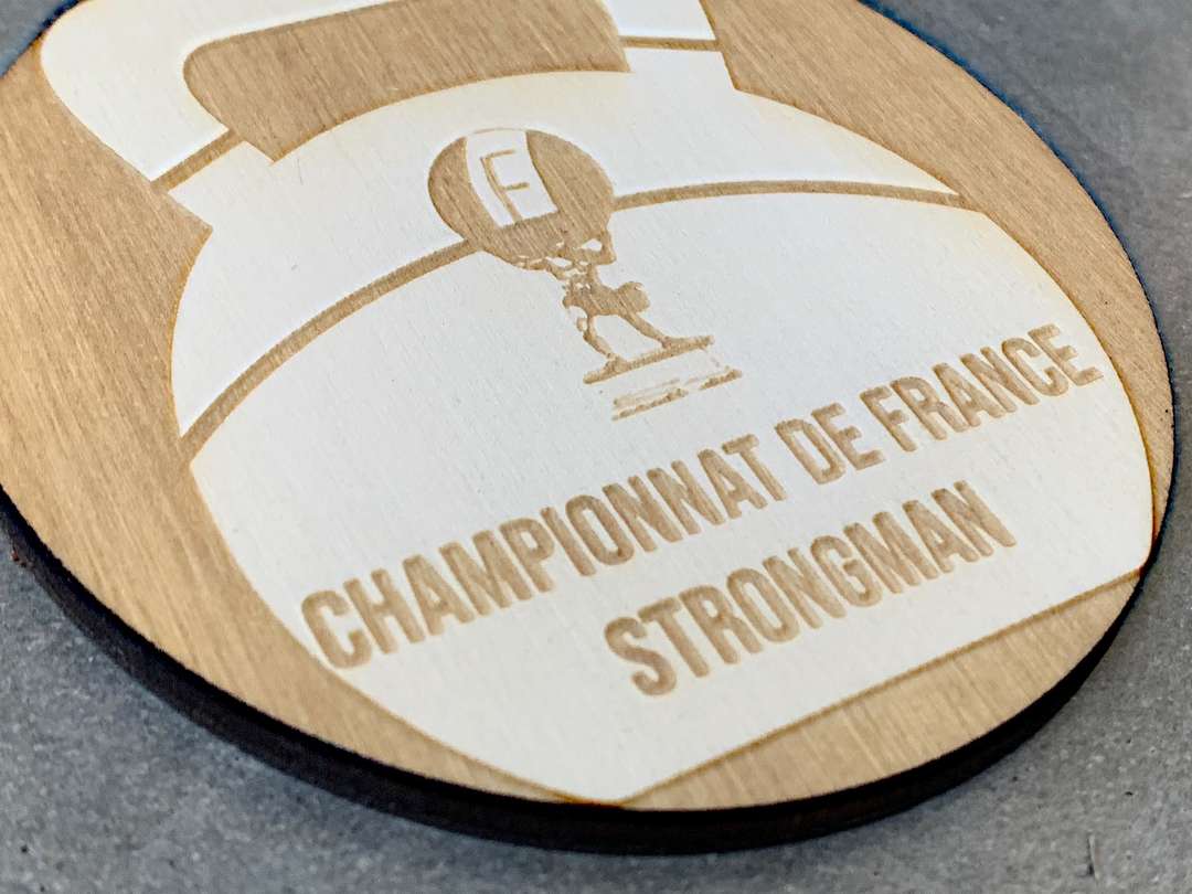 Gravure et découpe laser de médailles en bois pour le championnat de france strongman organisé par la break out company