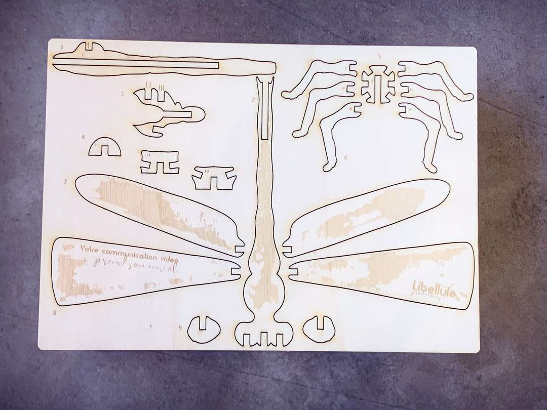 Gravure et découpe Laser d'une carte de vœux en bois construction à monter soi-même pour l'agence de communication Libellule Production