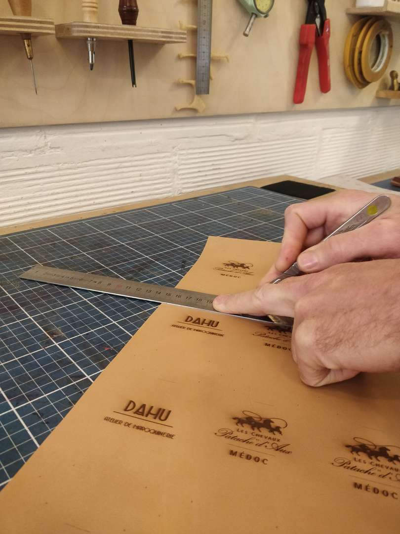 Fabrication d'étiquettes pour portes bagages en cuir pour les châteaux Patache d'Aux en partenariat avec l'atelier de maroquinerie Dahu