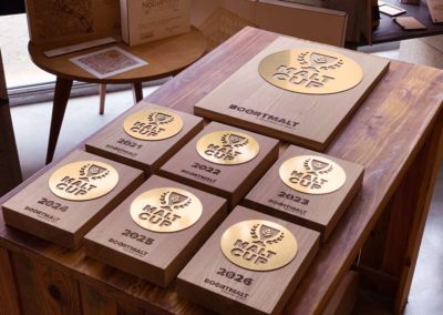 Vue détaillée des trophées Malt Cup 2021 en bois de Bourgogne PEFC et acrylique or.