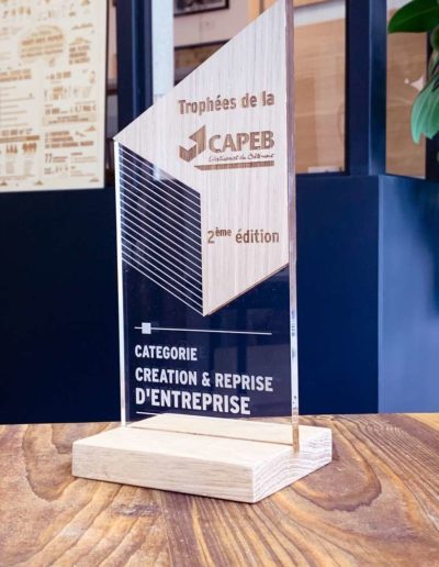 Découpe et gravure laser de trophées récompense en acrylique et bois à l'occasion d'un évènement organisé par la CAPEB