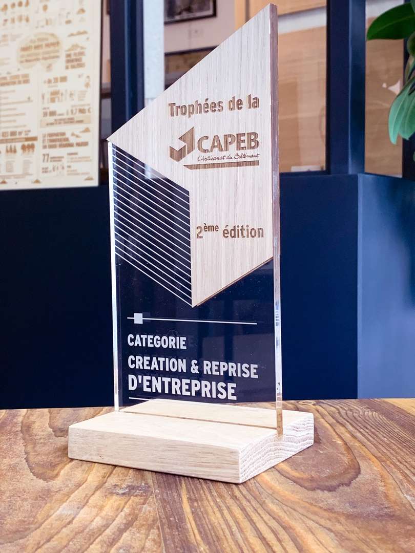 Découpe et gravure laser de trophées récompense en acrylique et bois à l'occasion d'un évènement organisé par la CAPEB