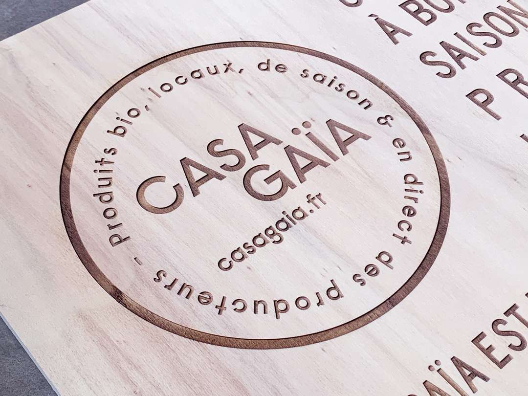 Gravure et découpe laser d'un panneau signalétique stop trottoir en bois pour le restaurant BIO Casa Gaia