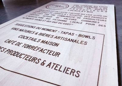 Gravure et découpe laser d'un panneau signalétique stop trottoir en bois pour le restaurant BIO Casa Gaia