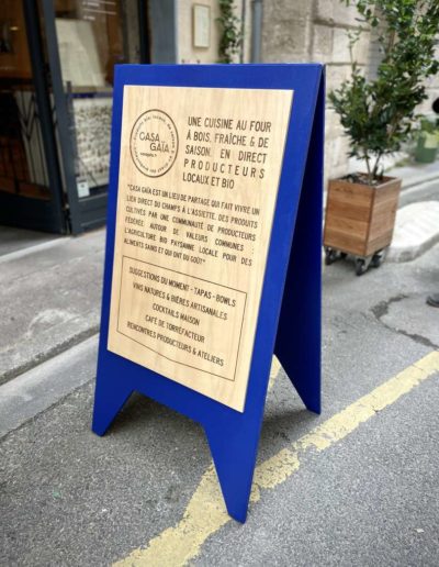 Gravure et découpe laser d'un panneau signalétique stop trottoir en bois pour le restaurant BIO Casa Gaia